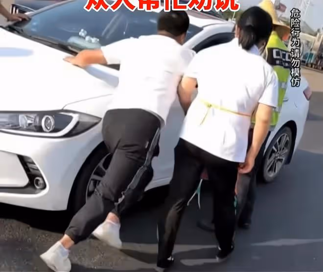 夫妻倆服務區吵架,妻子賭氣要開車上高速,丈夫忙趴引擎蓋上阻攔