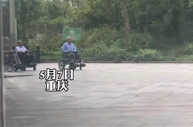 大爺和一群大媽跳舞,幾個坐輪椅大爺遠遠觀看,羨慕的眼神藏不住
