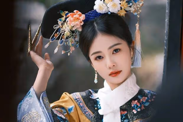 白鹿穿鵝黃旗裝清新明媚，手拿團扇眼神純真無瑕
