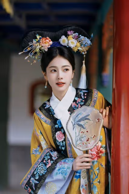 白鹿穿鵝黃旗裝清新明媚，手拿團扇眼神純真無瑕