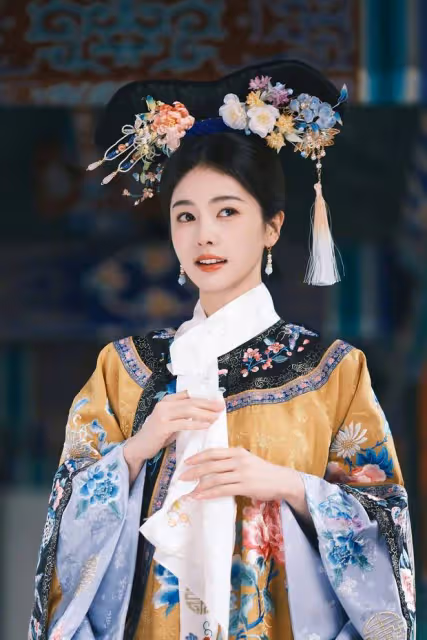 白鹿穿鵝黃旗裝清新明媚，手拿團扇眼神純真無瑕