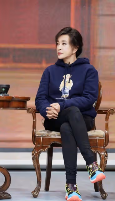 劉曉慶現身機場,穿修身褲雙腿纖細胯太大,一身明黃色T恤真顯黑