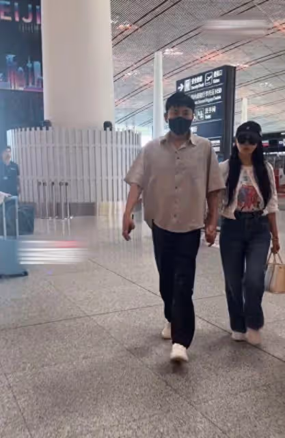 伊能靜與老公手牽手走機場,秦昊嚴肅得嚇人,與老婆表情截然相反