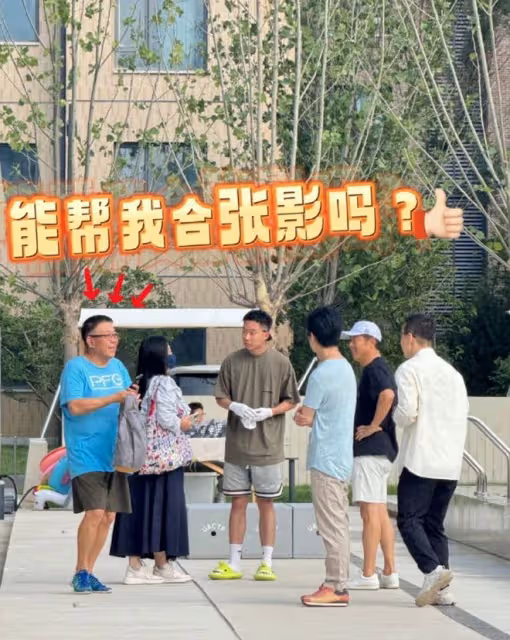 李健幫阿那亞村長拍照,大方端著手機半蹲著,老婆孟小蓓戴著口罩