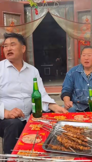 大衣哥帶老婆吃燒烤,邊吃肉串邊喝酒,表情十分滿足