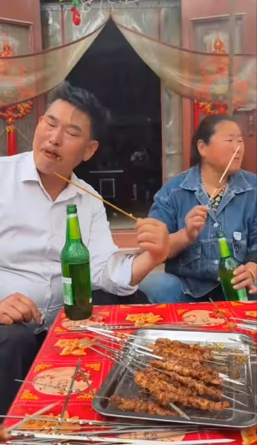 大衣哥帶老婆吃燒烤,邊吃肉串邊喝酒,表情十分滿足