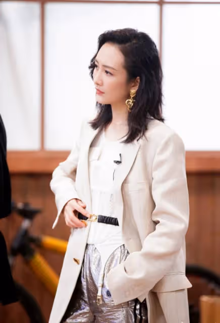 王鷗真會玩，西裝內搭束胸，腰帶里系一半外系一半，真夠前衛