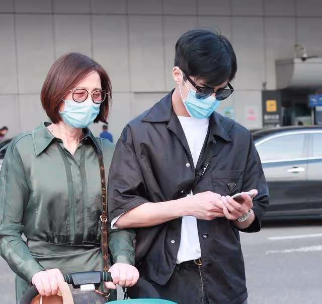姜潮攜媽媽走機場，媽媽一身墨綠襯衫裙優雅知性，比姜潮還搶鏡