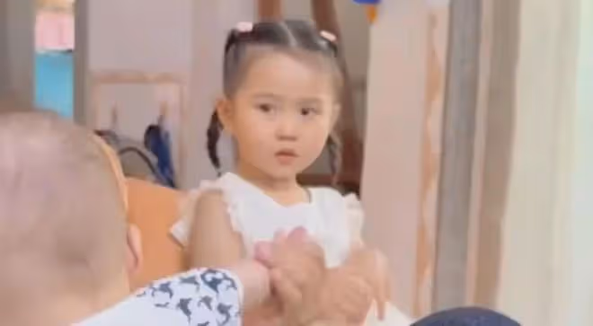 女子專心哄二胎兒子，大女兒委屈躲一旁偷偷抹淚，一句話太心酸