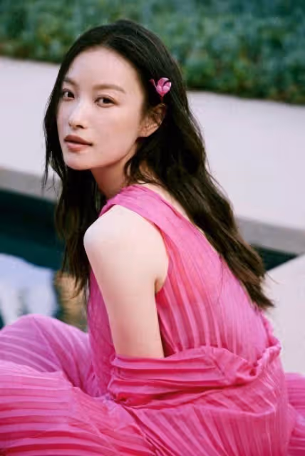 倪妮玫紅裙海邊漫步，嘴銜鮮花眼神撩人：這是何等的風情萬種！