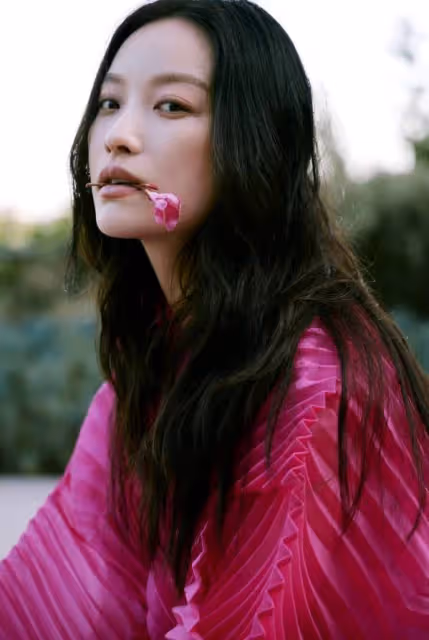 倪妮玫紅裙海邊漫步，嘴銜鮮花眼神撩人：這是何等的風情萬種！