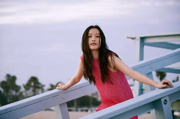 倪妮玫紅裙海邊漫步，嘴銜鮮花眼神撩人：這是何等的風情萬種！