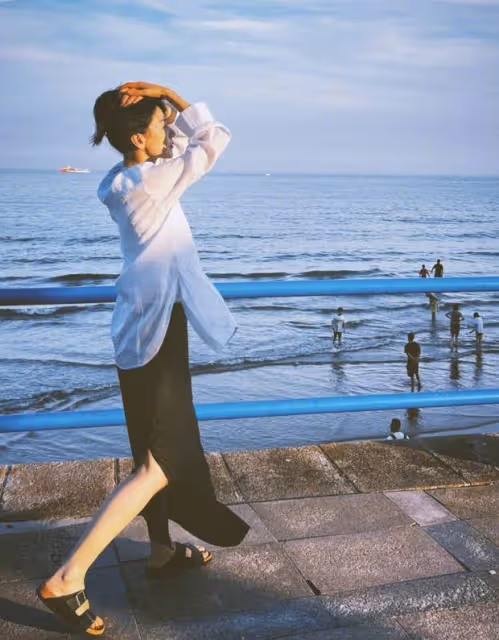 高圓圓海濱漫步，白襯衫黑裙造型氛圍感爆棚，網友：這是夏日最美的風景線！