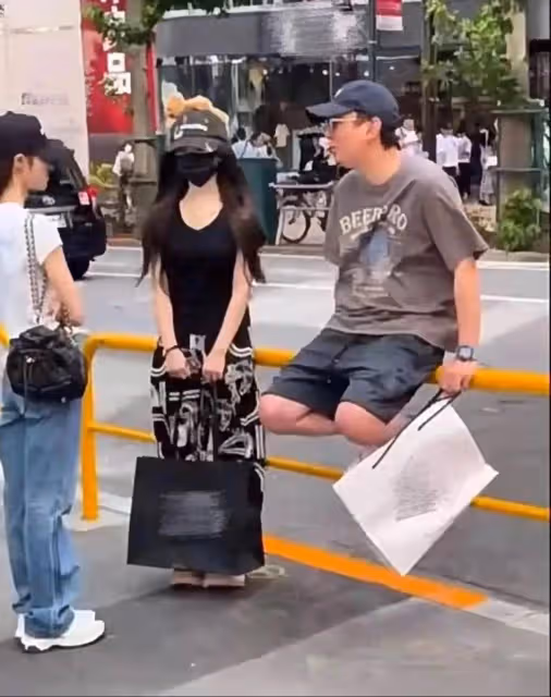 王思聰街頭坐欄杆和美女閒聊，網友吐槽像街溜子，網傳認下女兒