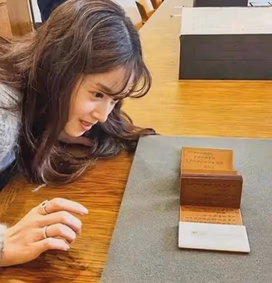 章澤天參加清華校友藝術展,半蹲在地上工作,戴棒球帽穿著簡單