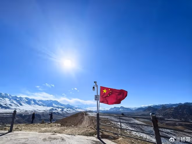 楊冪曬旅行美照,激動與國旗合影,扎雙辮背粉包少女感超足