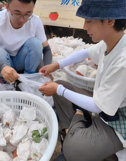 王冰冰丁真街頭賣桃，席地而坐汗直流，每人限購五個兩小時全賣光