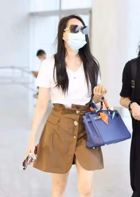 伊能靜真把自己當小姑娘,走機場打扮玩下衣失蹤,一雙美腿真撩人,網友:不敢相信這雙腿是54歲