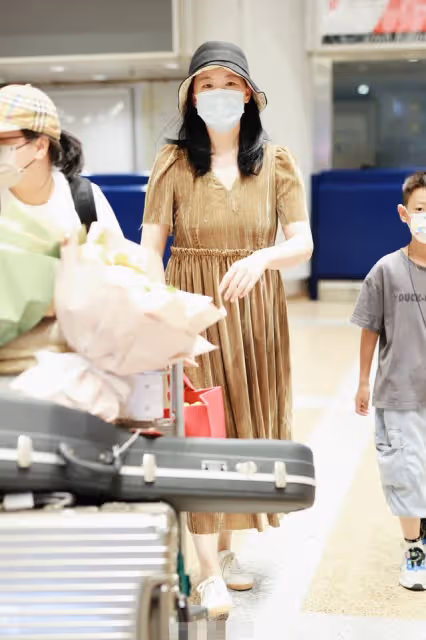 52歲柏林影后罕見露面,打扮樸素舉止接地氣,身邊小男孩身份成疑