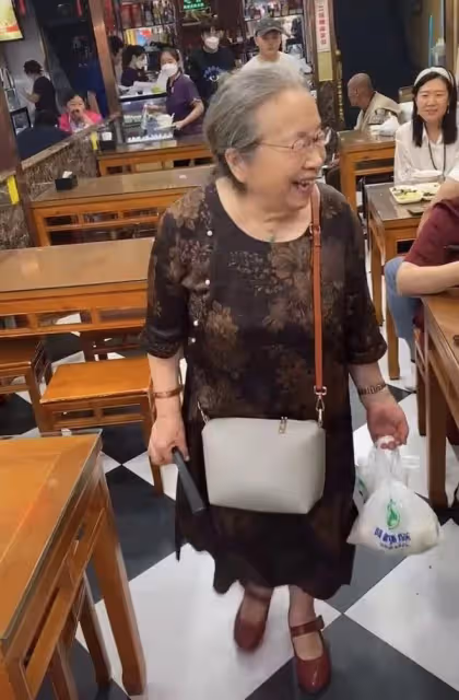 86歲李明啟獨自逛街邊小吃店,白髮蹣跚提兩袋饃,笑容慈祥引圍觀