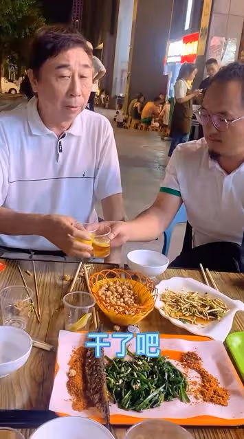 64歲馮鞏在街頭擼串不講究,與友人拼酒一口乾,不戴口罩無人識