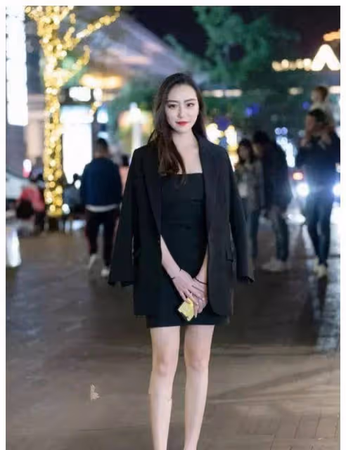 小姐姐身上穿著一件黑色的抹胸連衣裙，顯示出一種迷離的姿態