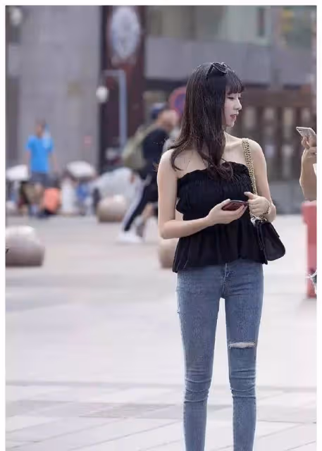 小姐姐白色抹胸上衣搭配緊身的藍色九分牛仔褲，看上去格外的迷人