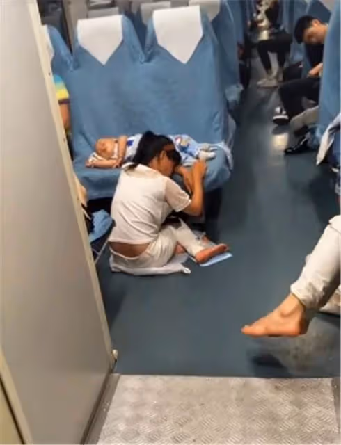 獨自帶娃出門的年輕媽媽走紅!火車上孩子睡著後,媽媽趴在地上守護,網友:唯有母愛能如此