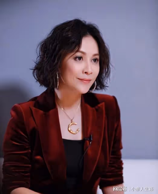劉嘉玲參加薛松畫展，黑色西裝搭配銀色項鍊，和友人合影非常親切