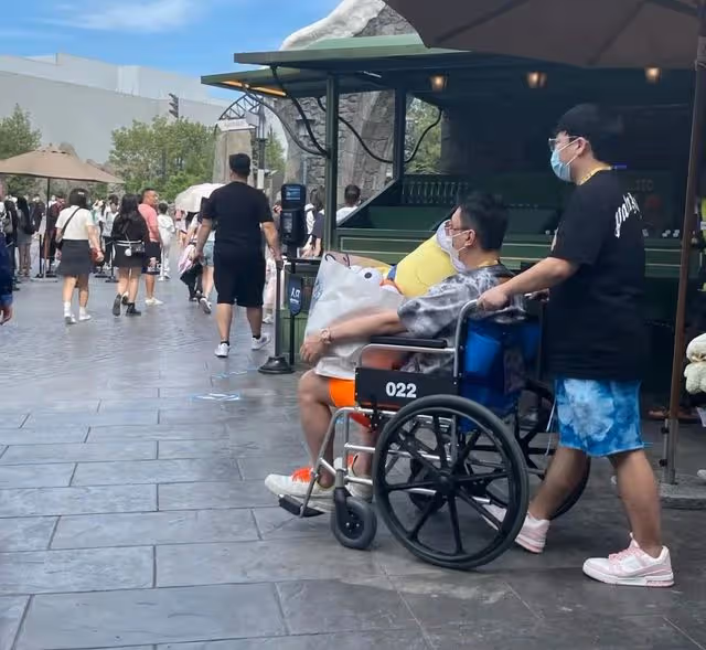 王思聰坐輪椅現身!走累了專人推車逛樂園,一手抱一美女艷福不淺