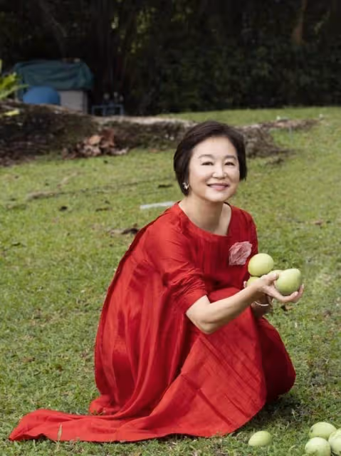 林青霞近照曝光!在自家果園摘果子,穿紅裙赤腳坐在樹樁上,67歲狀態像40歲