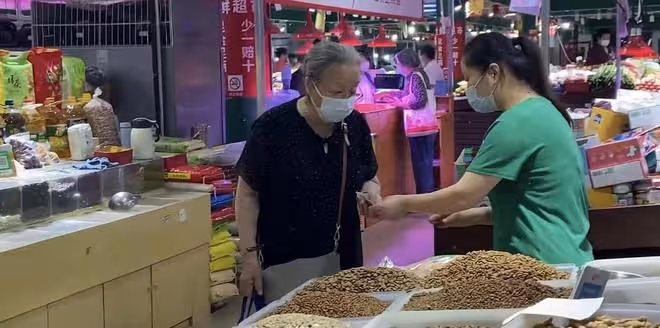 86歲「容嬤嬤」逛菜市場,打扮簡樸手提布袋包,投喂流浪貓有愛心