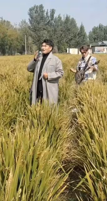 大衣哥朱之文近況曝光,穿著體面泥地里唱歌,腳踩麥田擺拍惹爭議