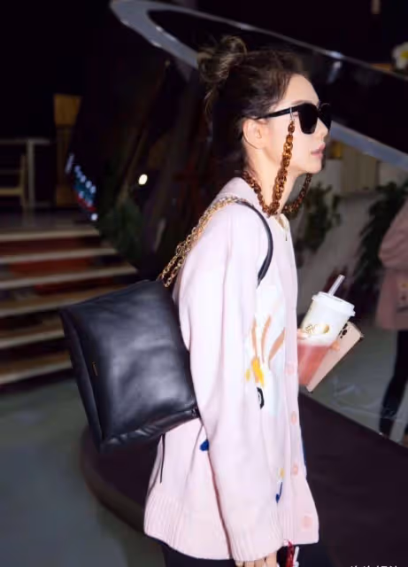 戚薇拌美同時還不忘耍酷，戴耳鏈式墨鏡穿粉美針織外套，可甜可鹽真讓人上頭