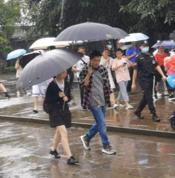 謝霆鋒錄節目被網友偶遇，雨中撐傘與美女同行保持距離