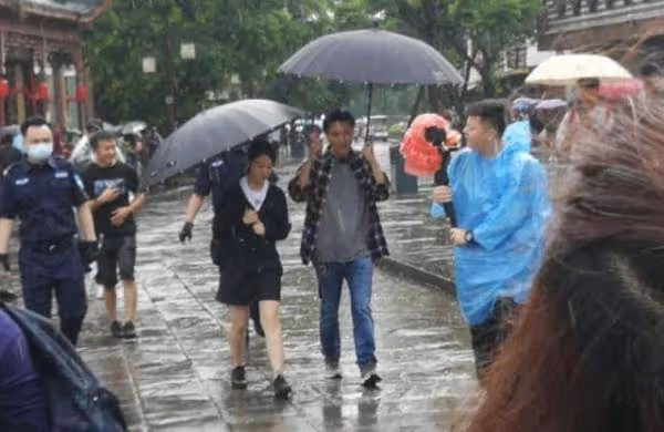 謝霆鋒錄節目被網友偶遇，雨中撐傘與美女同行保持距離