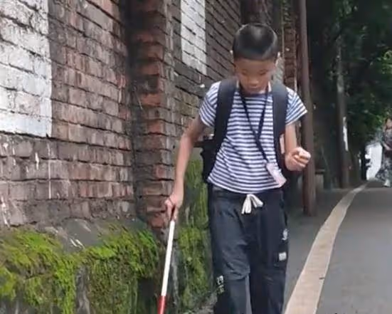 眼盲男孩獨自去上學，媽媽悄悄跟隨保護，路人默默伸出援手
