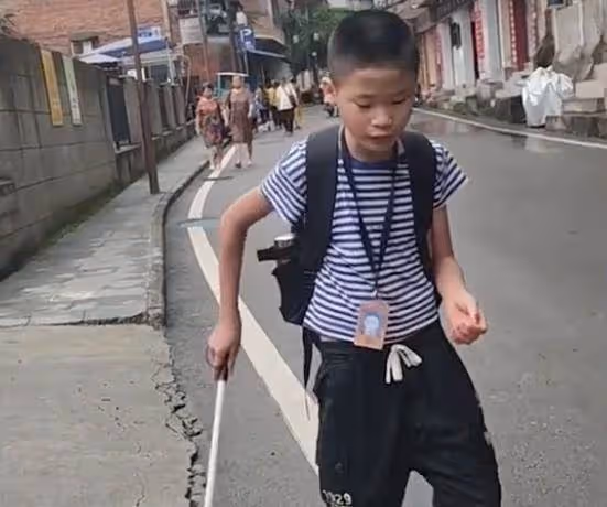 眼盲男孩獨自去上學，媽媽悄悄跟隨保護，路人默默伸出援手