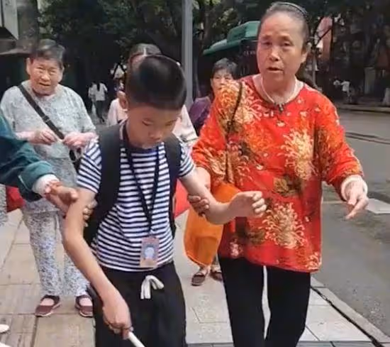 眼盲男孩獨自去上學，媽媽悄悄跟隨保護，路人默默伸出援手