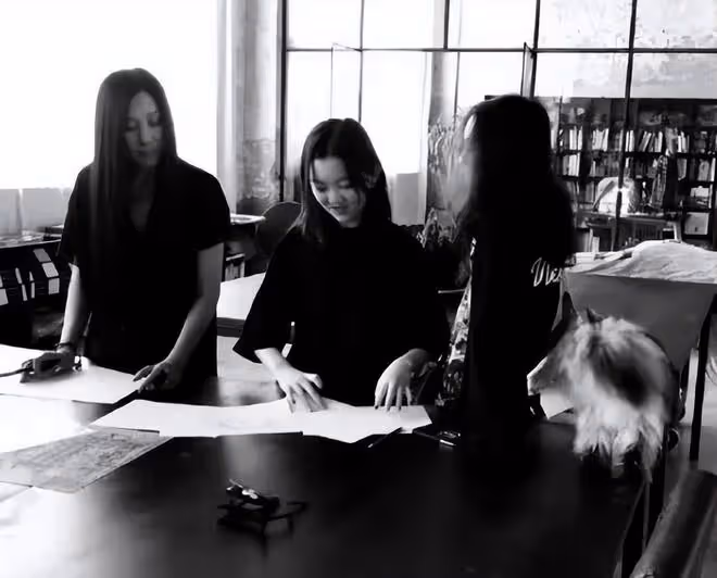 李嫣分享學校宿舍內景：書桌放著捲筒紙和畫筆，牆上貼著課表作品