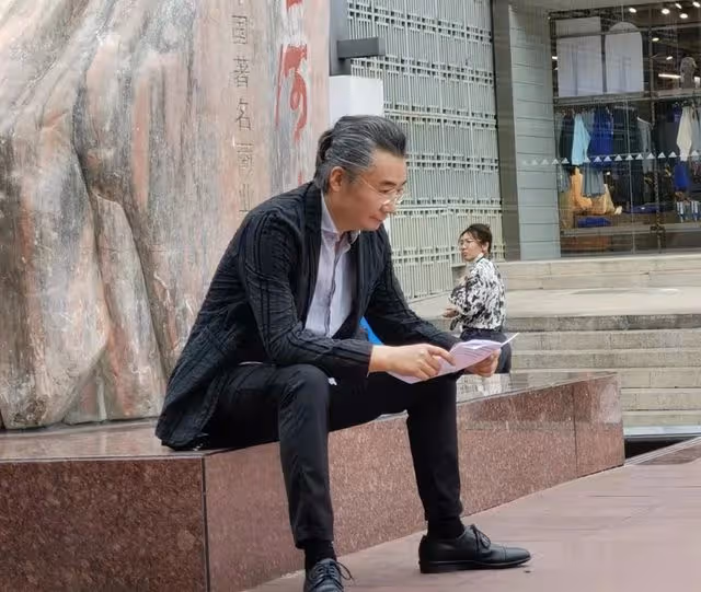 央視主持人高博坐街邊被偶遇,西裝革履打扮斯文,43歲已滿頭銀髮