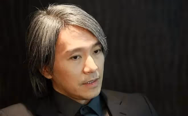 周星馳在辦公室寫「心想事成」符,桌子上擺著李小龍和他的功夫照