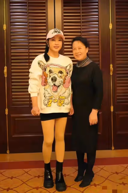 70歲劉曉慶參加同學聚會穿短裙露大腿,站在男女同學中間像一家三口