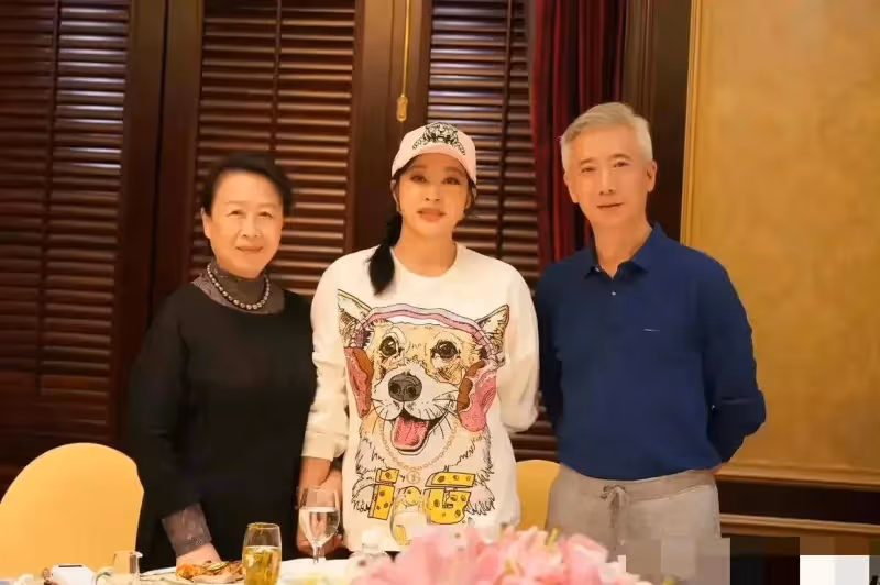 70歲劉曉慶參加同學聚會穿短裙露大腿,站在男女同學中間像一家三口