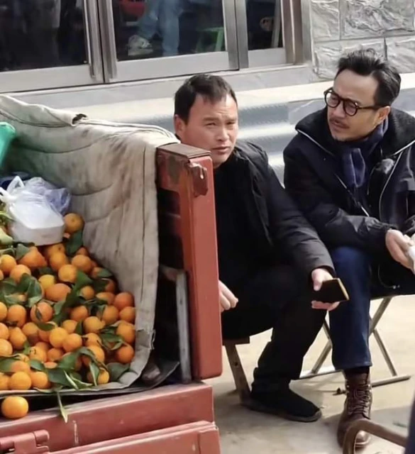 汪涵河南農村路邊攤賣藝,與水果攤主摟肩唱歌,坐小馬扎鬍子花白