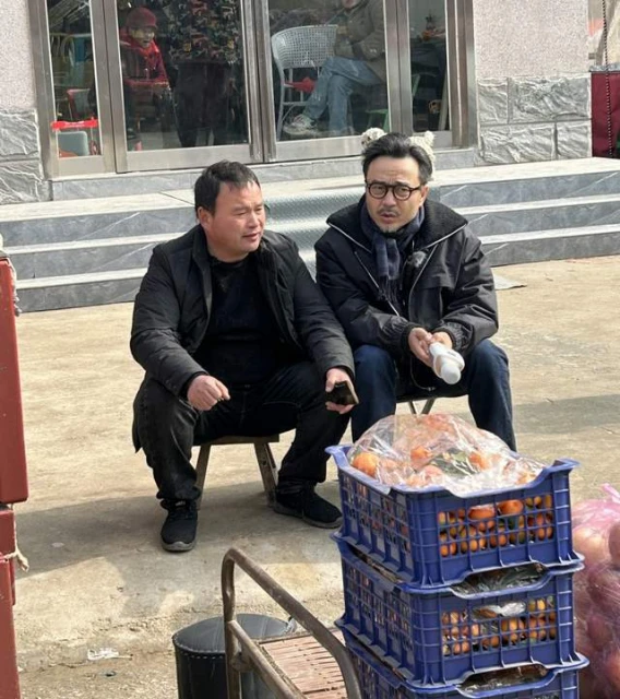 汪涵河南農村路邊攤賣藝,與水果攤主摟肩唱歌,坐小馬扎鬍子花白