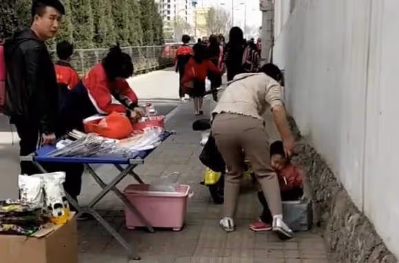「艱辛媽媽」擺攤帶娃兩不誤火了，坐在一旁打瞌睡的萌娃讓人心疼