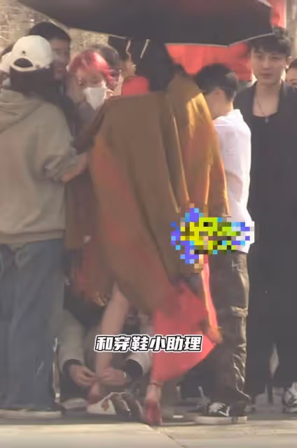 古力娜扎穿高開叉紅裙秀美腿,露底褲險走光,助理蹲地為其穿鞋