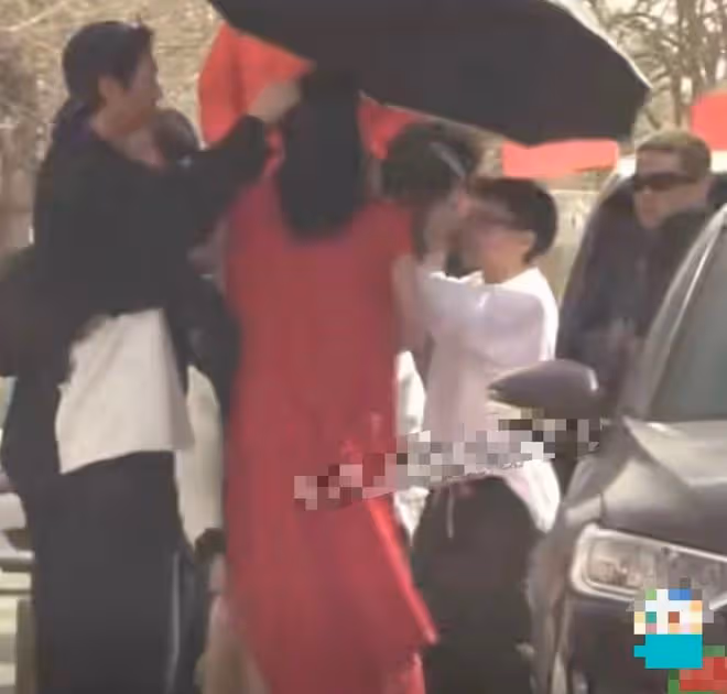 古力娜扎穿高開叉紅裙秀美腿,露底褲險走光,助理蹲地為其穿鞋
