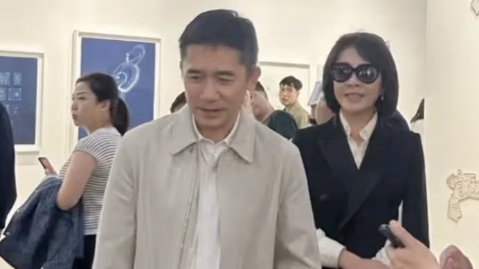 梁朝偉夫婦香港看展被偶遇，劉嘉玲穿百褶裙秀美腿，梁朝偉抿嘴好害羞